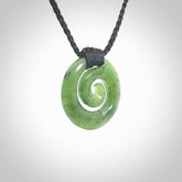 Hand carved British Columbian jade koru pendant. Delivered to you on a hand plaited black cord which is adjustable. Free delivery worldwide.